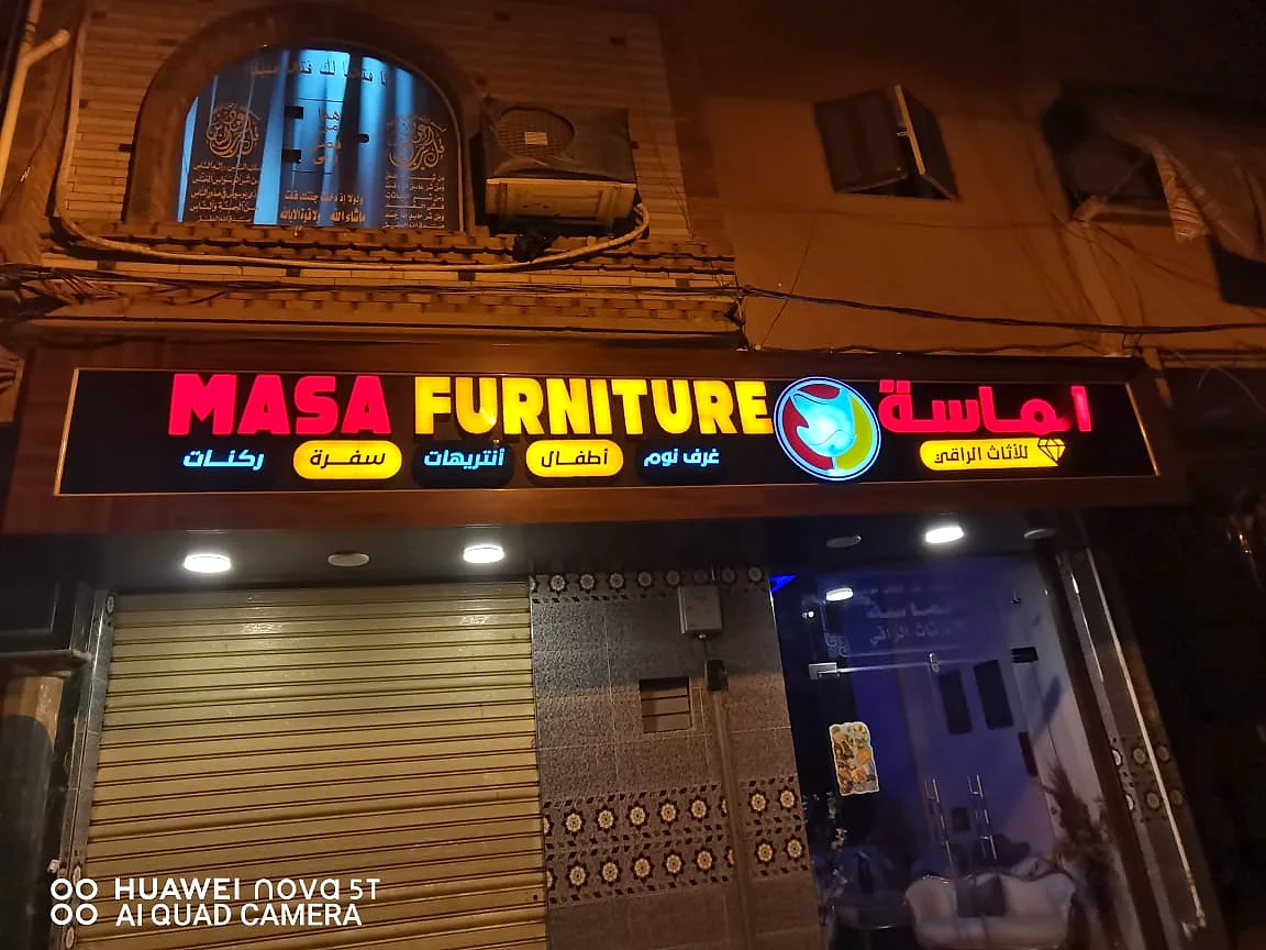 MASA FURNITURE — واجهة معرض أثاث بلافتة علوية طويلة وحروف أكريليك مضيئة متعددة الألوان مع إضاءة سبوت. من تنفيذ أبو الخير