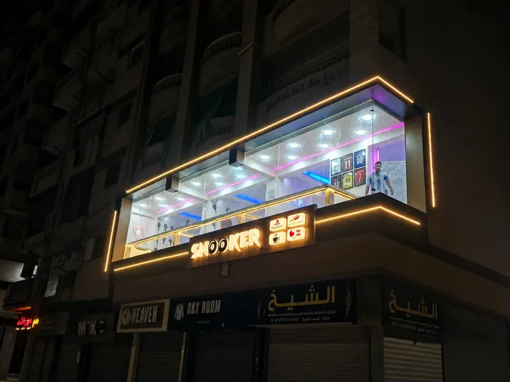 SNOOKER — واجهة علوية بإطار إضاءة خطّي وحروف مضيئة فوق واجهة المحل الزجاجية. من تنفيذ أبو الخير